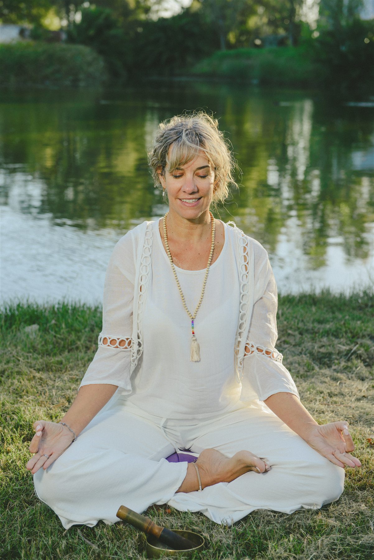 Rosana Rangone meditando junto al agua en un entorno natural